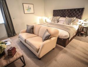 a bedroom with a large bed and a couch at Kings Head Hotel in Cirencester