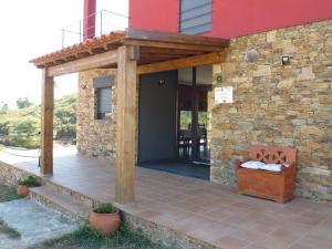 a patio with a wooden pergola on a house at Quinta do Favacal - Agroturismo - Serra da Estrela in Casegas