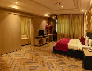 a hotel room with a bed and a television at The Orlov in Babarpur +7 photos