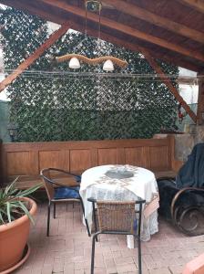 a table and chairs on a patio with a green hedge at Casa Slanic House in Slănic-Moldova