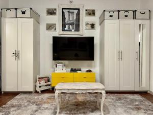 a living room with white cabinets and a tv at Live As Florentine in Florence