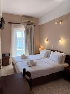 a bedroom with two large beds and a window at Hotel Lemnos in Myrina