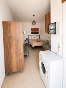 a room with a washing machine and a bed at University Apartment in Heraklio