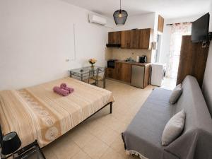 a room with a bed and a couch and a kitchen at University Apartment in Heraklio
