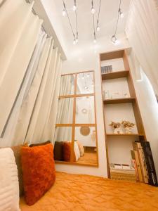 a bedroom with white curtains and a mirror at Hiraya Luna in Manila