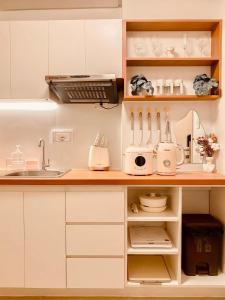 a kitchen with white cabinets and a counter with appliances at Hiraya Luna in Manila