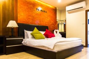 a bedroom with a bed with colorful pillows at Hotel De Nara in Chiang Mai