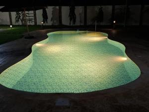 a swimming pool lit up at night with lights at Ferienhaus Vacation Villa Diani Beach in Kinondo +13 photos