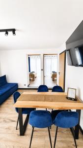 a dining room with a table and blue chairs at Apartamenty Pod Wyciągiem in Wisła