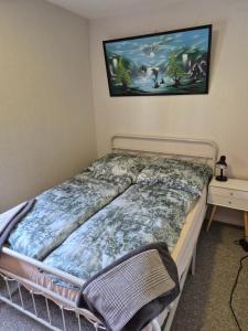 a bedroom with a bed with a picture on the wall at Ferienwohnung/Apartment Siegen in Siegen