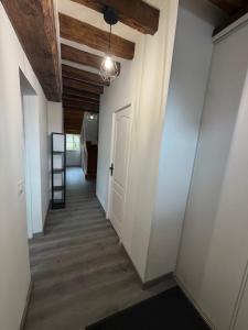 a hallway with white walls and a wooden ceiling at Maison de bourg de village in Dame-Marie-les-Bois