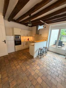 a kitchen with white cabinets and a table and chairs at Maison de bourg de village in Dame-Marie-les-Bois