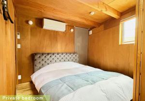 a bedroom with a bed in a small room at SUMITSUGU HOUSE Atelier in Kumamoto