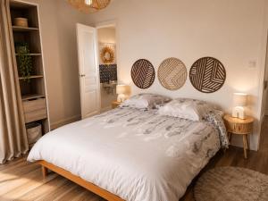 a bedroom with a large white bed with three mirrors on the wall at Entre Rails & Rives in Montbard