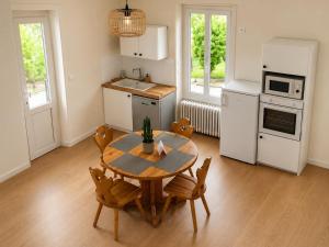 a kitchen with a table and chairs in a room at Entre Rails & Rives in Montbard