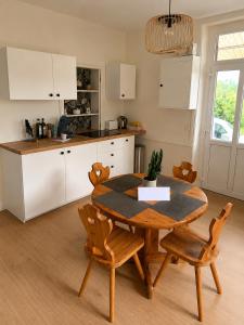 a kitchen with a wooden table and chairs in a kitchen at Entre Rails & Rives in Montbard +5 photos