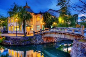 a bridge over a river in front of a building at TOMOSHIBI Kurashiki Zen House Near Bikan Historical Quarter 美観地区近く 和モダン一棟貸し in Kurashiki