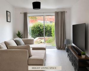 a living room with a couch and a flat screen tv at Stylish 4BR Home - Sleeps 7 - Parking & WiFi in Nottingham