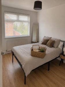 a bedroom with a large bed with a basket on it at Stylish 4BR Home - Sleeps 7 - Parking & WiFi in Nottingham +10 photos