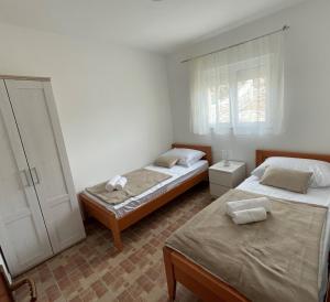 a bedroom with two beds and a window at Apartmani Arta 3 in Drage