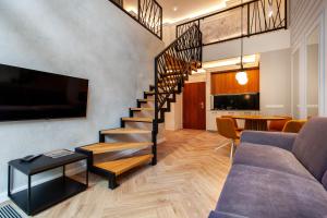 a living room with a staircase with a couch and a table at Amber Elite Apartments in Stegna