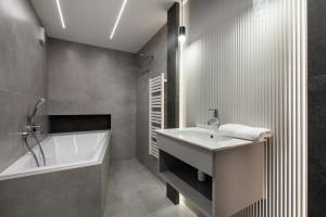 a bathroom with a tub and a sink and a bath tubermottermott at Amber Elite Apartments in Stegna +19 photos