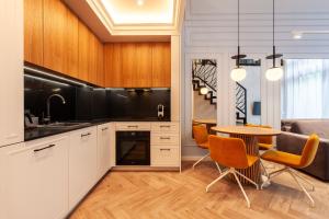 a kitchen with white cabinets and a table with chairs at Amber Elite Apartments in Stegna