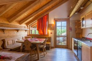 a kitchen with a table and a dining room at Chalet La Stua in Cavalese
