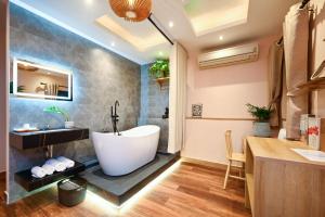 a bathroom with a tub and a sink at Harmony Stay - Ben Thanh Market in Ho Chi Minh City +22 photos