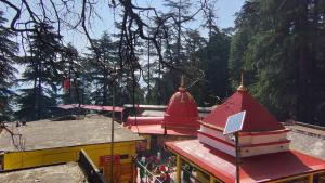 a view of a temple with red roofs and trees at VAIBHAV VILAs in Gangolihāt