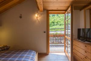 a bedroom with a bed and a sliding glass door at Chalet La Stua in Cavalese