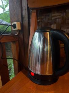 a black tea kettle sitting on a wooden table at Tetebatu Cabin Hut in Tetebatu