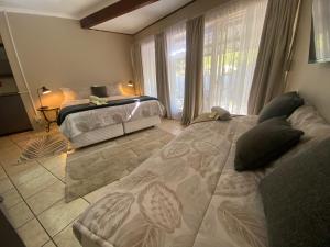 a bedroom with two beds and a window at Slaapnet Guesthouse Long Stay Accommodation Wilkoppies in Klerksdorp