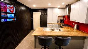 a kitchen with a sink and two bar stools at The Crossing Lodge in National Park