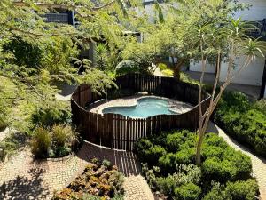 a small pool in a wooden fence in a garden at Industrial CHIC Apartment 113 - Luxury City Escape, Washing Machine & Fast WiFi in Johannesburg