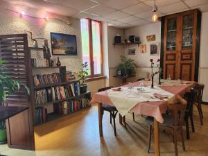 a dining room with a table and a book shelf at Hote de l'île chez Wendy et Fred in Jumeaux