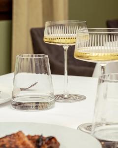 two wine glasses sitting on a table with food at Locanda Confini in Dolo