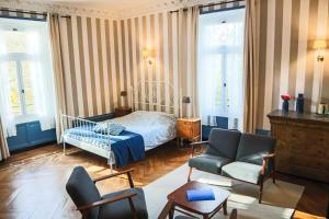 a bedroom with a bed and a couch and a chair at Domaine des Lilas in Saint-Germain-Lembron