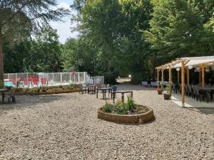 a park with tables and chairs and a tent at Domaine des Lilas in Saint-Germain-Lembron