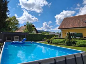 a swimming pool in the yard of a house at Lauras Ferienwohnung - Ihre Wohlfühloase in der Südweststeiermark mit Garten, Pool, Biotop & Weinbar in Eibiswald