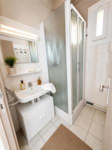 a white bathroom with a shower and a sink at Résidence les 4 Horizons in Cerbère +34 photos
