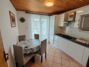 a kitchen with a table and chairs in a room at Gama 2 in Vir