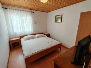 a small bedroom with a bed and a television at Gama 2 in Vir