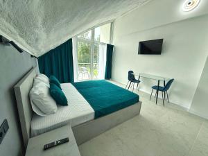 a bedroom with a bed and a desk and a window at VELAR Apartment in Skhidnitsa