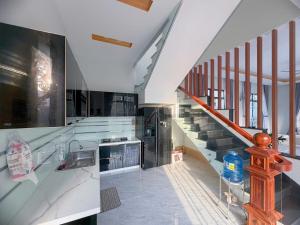 a kitchen with a sink and a staircase at Arden Reserve Villa in Binh Thai