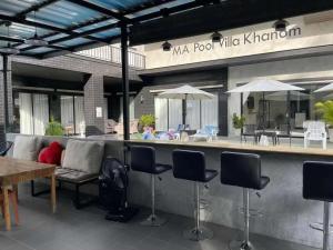 a patio with a bar with chairs and tables at Ma PoolVilla Khanom in Khanom +37 photos