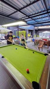 a group of people standing around a pool table at Ma PoolVilla Khanom in Khanom