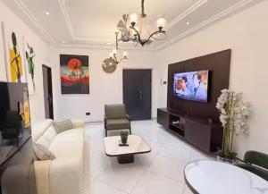 a living room with a couch and a tv at Pinnacle Apartment Lekki in Lekki