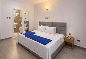 a bedroom with a large bed and a bathroom at Pinnacle Apartment Lekki in Lekki