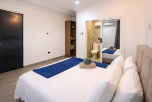 a bedroom with a large white bed and a mirror at Pinnacle Apartment Lekki in Lekki